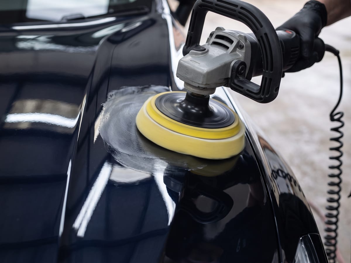 Machine polishing a car panel during the detailing stage of preparation